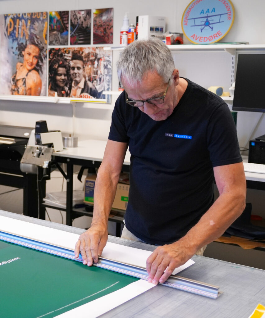 Banner med tryk Medarbejder tilpasser stort banner i produktionen